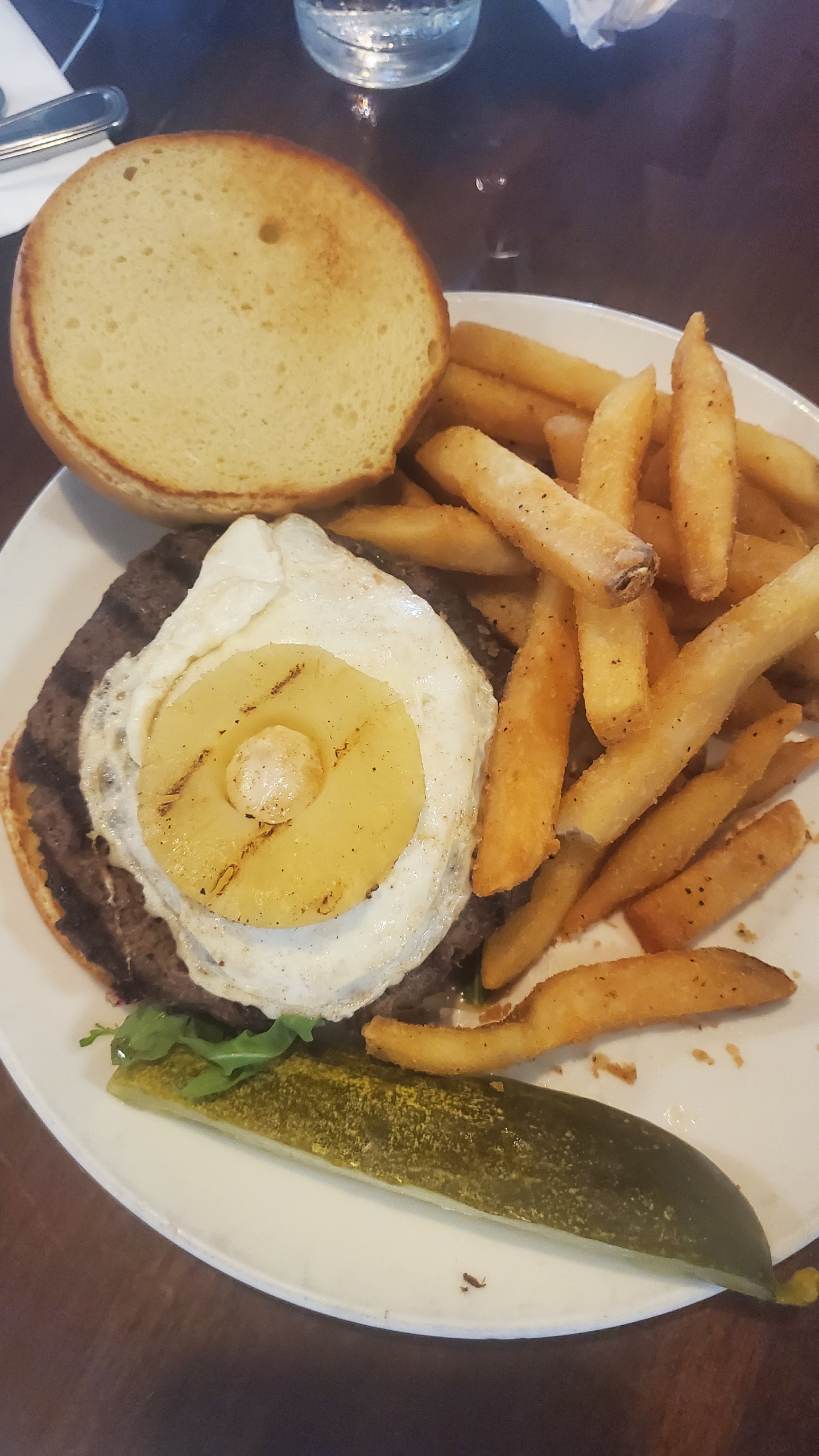 Pounders Restaurant burger with fried egg, fries, and pickle